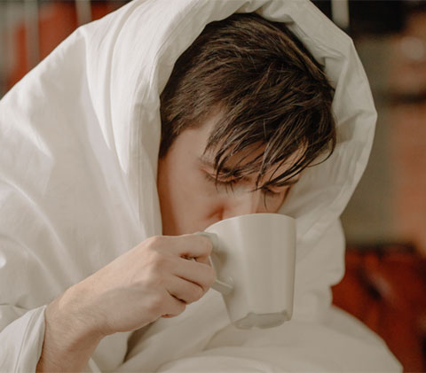 a sick man drinking a tea